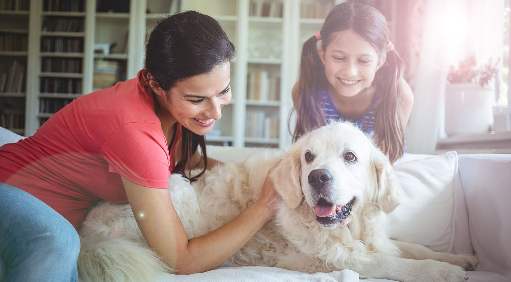Mom and daughter petting dog 